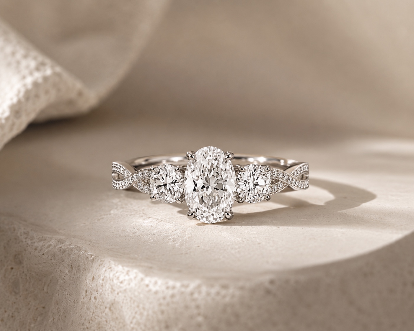 Oval trilogy diamond engagement ring with a twisted pavé band